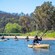 A small group of kayakers paddling on the Pambula River in New South Wales, Australia